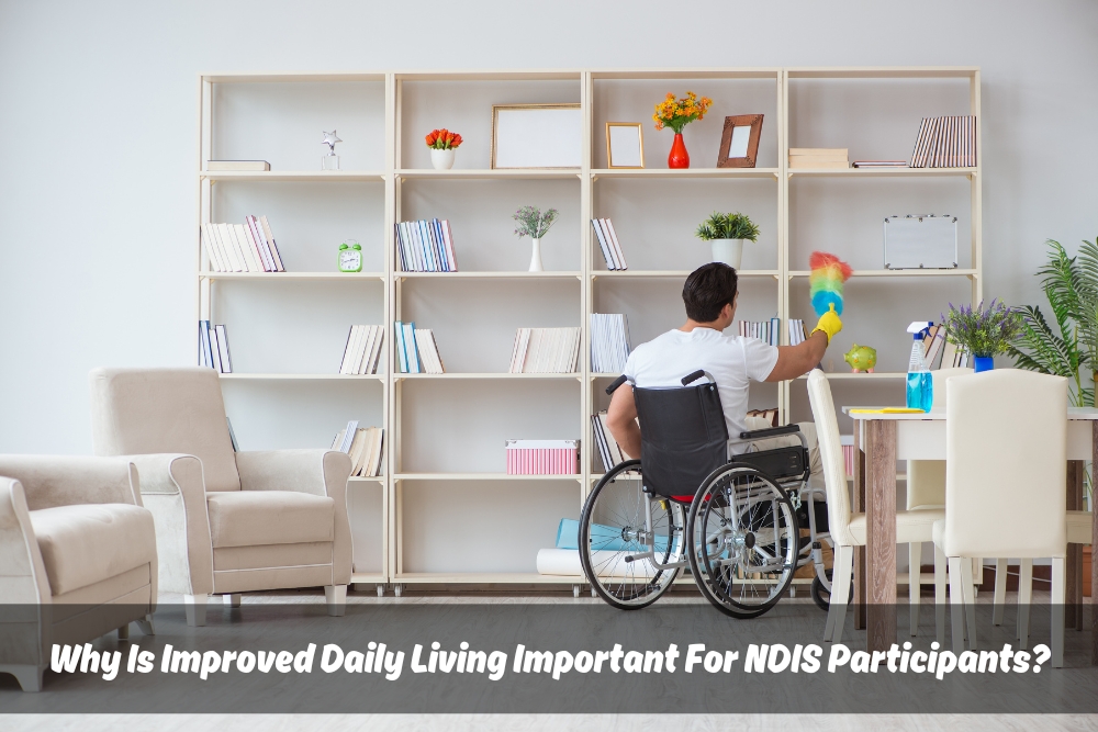 Man in wheelchair independently cleaning bookshelf, demonstrating NDIS Improved Daily Living skills.