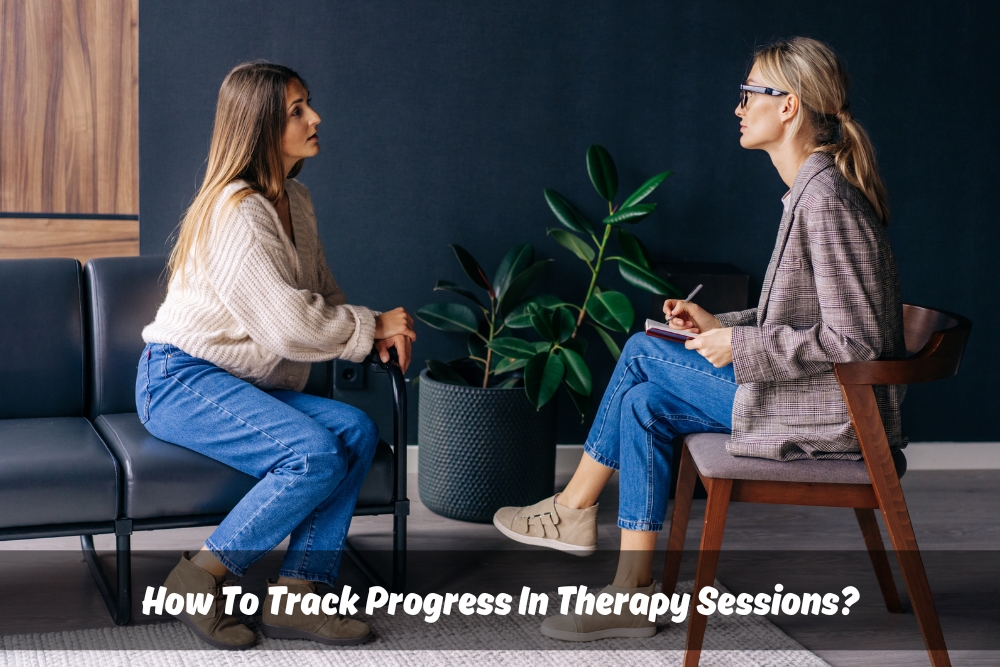 An image of a therapist and client sitting together, facing each other with a notebook. This portrays the collaborative nature of therapy and progress tracking.