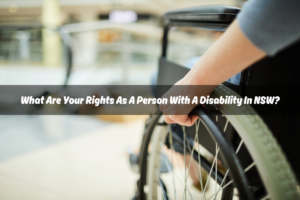 A person using a wheelchair in a public place. White text overlay "What Are Your Rights As A Person With A Disability In NSW?"