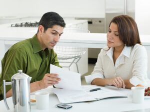 Couple reviewing documents at home, discussing how an NDIS guide can assist with behaviour support services.