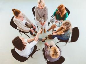 Aerial view of a group session discussing proactive strategies in positive behaviour support training.