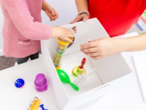 A child engaging in occupational therapy activities with toys, demonstrating how to help a child with developmental delay.