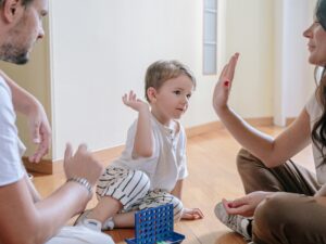 Parents playing an interactive game with their child, demonstrating how to help a child with developmental delay.