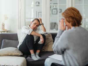 A woman in therapy discussing her mental health risk assessment with a professional counsellor.