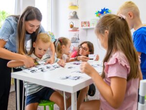 Children working on fine motor skills with therapists, showcasing occupational therapy benefits for cognitive and physical development.