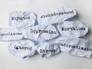 A handwritten note on paper reads "depression". This image represents the mental health condition and may trigger difficult emotions.