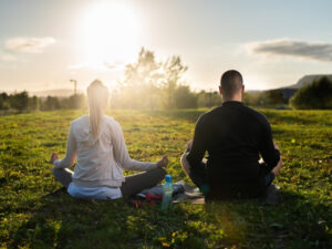 Two people practicing mindfulness meditation, focused on managing emotions and finding inner peace.